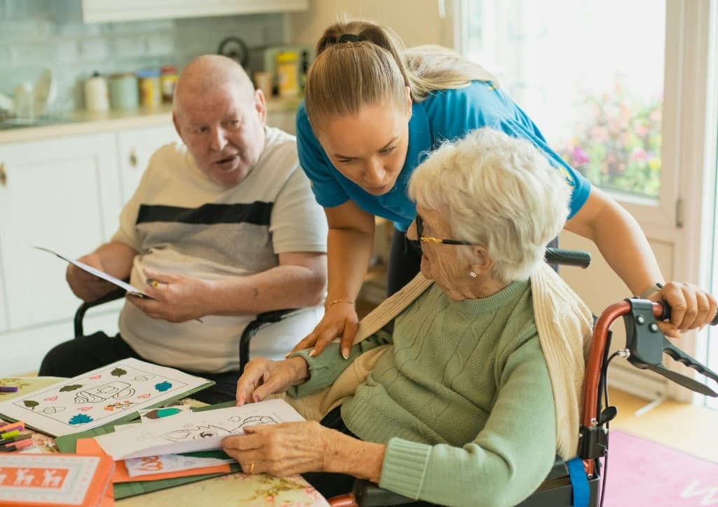 Cuidadora realizando actividades cognitivas con adultos mayores